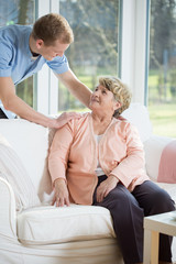 Wall Mural - Male nurse assisting retired woman