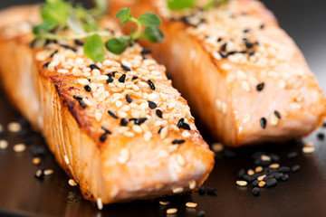 Wall Mural - Grilled salmon on black plate selective focus macro