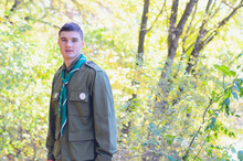 Portrait Of Boy Scout In Forest On Sunny Day
