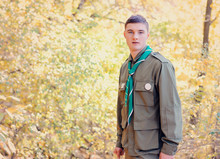 Portrait Of Boy Scout In Forest On Sunny Day