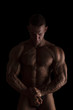 © Eskymaks - Bodybuilder posing isolated on black.