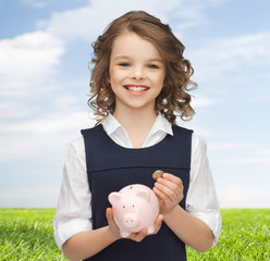 Wall Mural - happy girl holding piggy bank and coin