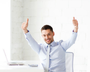 Wall Mural - happy businessman showing thumbs up in office