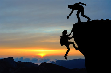 Wall Mural - Teamwork of two people man and girl on mountain