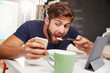 © Monkey Business - Man Eating Breakfast Whilst Using Digital Tablet And Phone