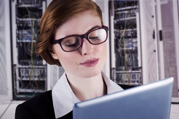 Poster - Composite image of redhead businesswoman using her tablet pc