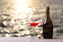 Bottle And Glass Of Red Wine On The Table Against The Sea