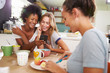 © Monkey Business - Female Friends Eating Breakfast Whilst Checking Mobile Phone