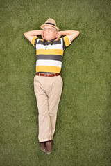 Poster - Relaxed senior gentleman lying on grass in a field