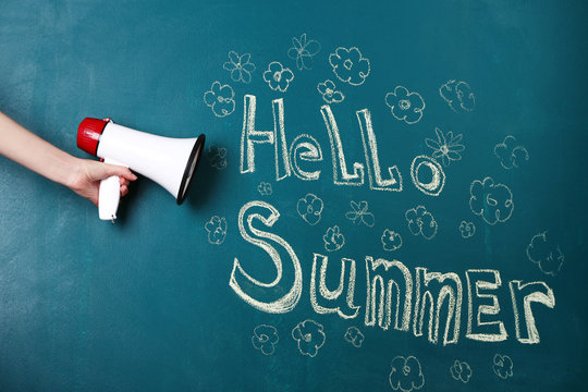 Hand holding megaphone on blackboard background