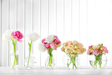 Beautiful Spring Flowers In Glass Vases On Planks Background
