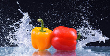 Macro Drops Of Water Fall On The Red And Yellow Pepper Splash