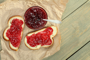 Poster - Toast with strawberry jam on a plate on a wooden background