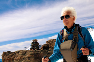 active senior man hiking in the snowy mountains