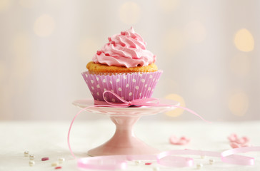 Wall Mural - Sweet cupcake on table on light background