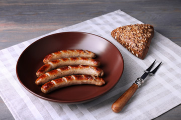 Sticker - Grilled sausages on plate with bread on table close up