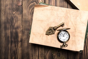 Wall Mural - Abstract. Vintage pocket watch, old book and a brass key on a