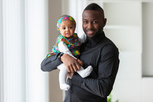 Young African American Father Holding With Her Baby Girl