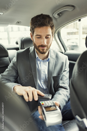 Fotomural Man paying the taxi with the mobile phone. NFC technology
