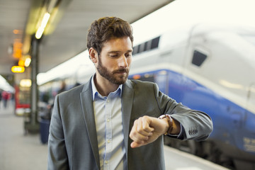 Man looks his watch on the platform station