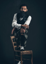 Bearded Stylish Man Standing With Foot On A Chair