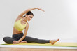 © puhhha - Woman doing stretching exercises against white