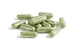 Capsules of green herbal supplement product isolated on white ba