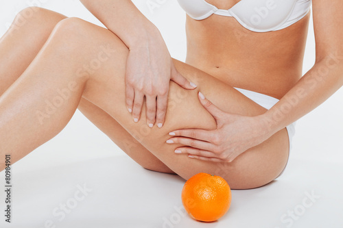 Fotografía Beautiful female body with orange on a white background