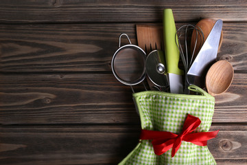 Wall Mural - Set of kitchen utensils in mitten on wooden planks background