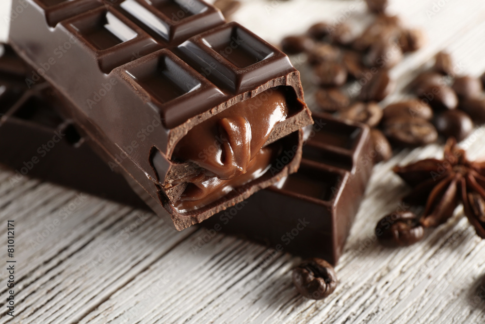Stuffed chocolate with coffee beans on wooden table, closeup