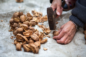 Wall Mural - Woman crushing walnuts outdoor