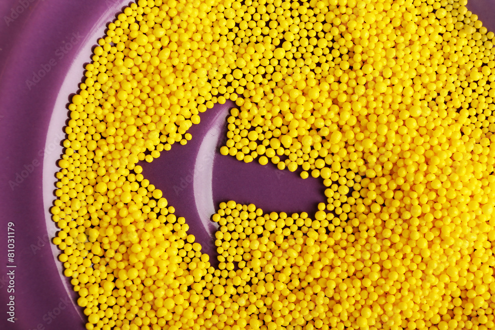 Arrow on purple plate with color beads, closeup
