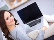 © shefkate - Happy pretty woman using laptop sitting on  sofa