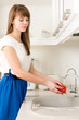 © autau - Young female washing tomatoes under tap water