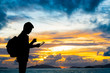 © littlestocker - Silhouette man with digital tablet in hands at sunset beach