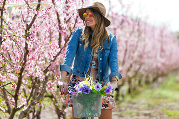 Wall Mural - Beautiful young woman with a vintage bike in the field.