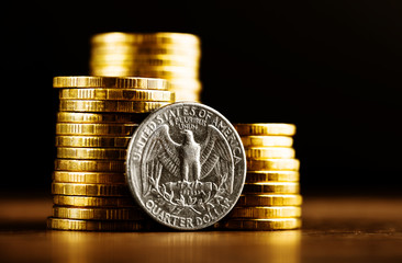 us quarter dollar coin and gold money on the desk