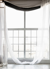 High Window From Ceiling To Floor With Long White Curtains