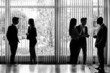 © javiindy - Silhouettes of businesspeople interacting background business ce