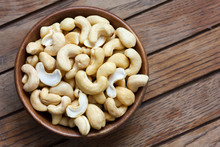 Wooden Bowl Of Cashew Nuts From Above. On Dark Wood.