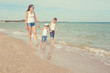 © Malsveta - Mother and her two sons having fun on the beach