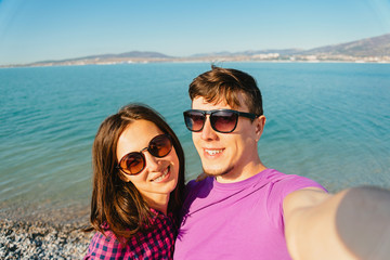 Happy loving couple taking self-portrait on beach