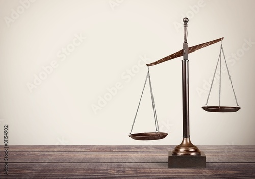 Fotomural Lawyer. Law scales on table in front black background. Symbol of