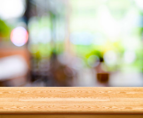 Poster - Empty wood table top with coffee shop blur with bokeh background