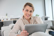 © goodluz - Mature woman sitting in sofa and websurfing with tablet