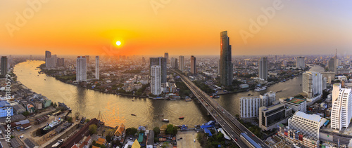 Naklejka dekoracyjna River in Bangkok city with high office building at sunset