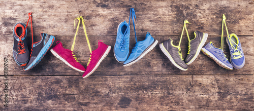 Cuadros en Lienzo Sports shoes hang on a nail on a wooden fence background