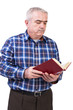 Portrait of senior man standing and reading a book