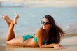 tanned brunette laying on the beach