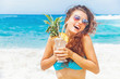 © Mila Supinskaya  - happy tourist woman holding a cocktail in her hands on a beach